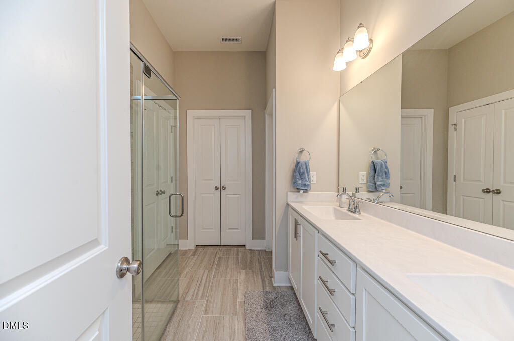22 Camille Brooks Drive Angier, NC 27501 - Photo 10 of 52 a spacious bathroom with a double vanity sink and mirror
