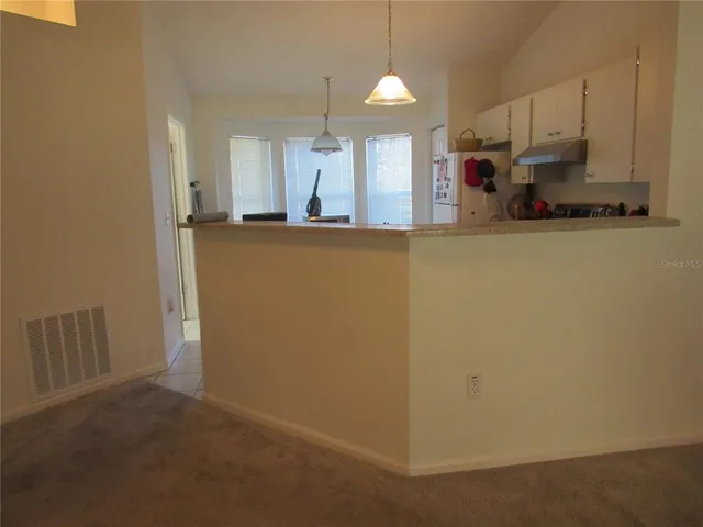 a kitchen with a stove top oven and cabinets