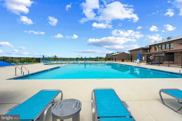 a view of swimming pool with seating space and yard in back