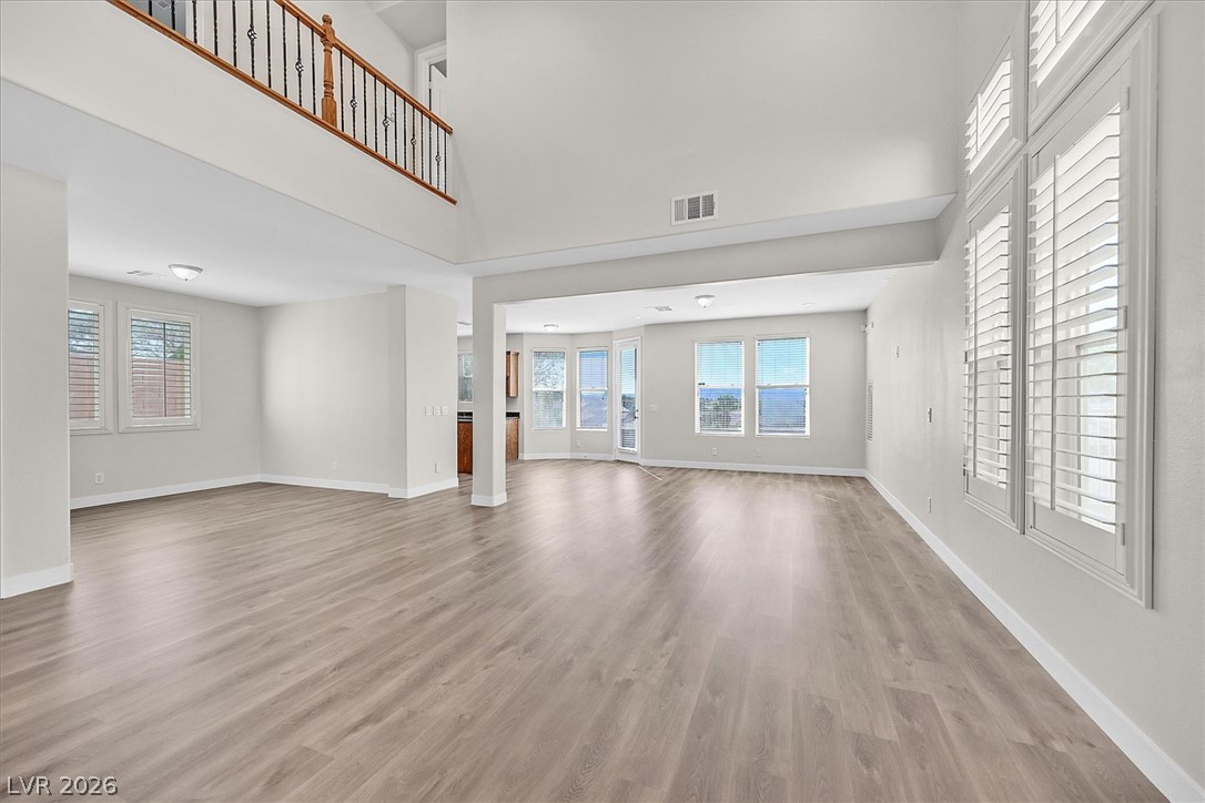 2447 Kaymin Ridge Road Henderson, NV 89052 - Photo 7 of 40 High vaulted ceilings and tall shuttered windows elevate this open, light-filled living space.