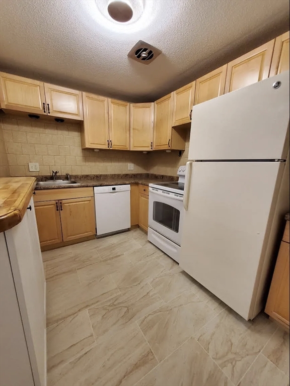 A2 Colonial Drive, Unit 10 Andover, MA 01810 - Photo 2 of 20 a kitchen with granite countertop stainless steel appliances a refrigerator a sink and a stove
