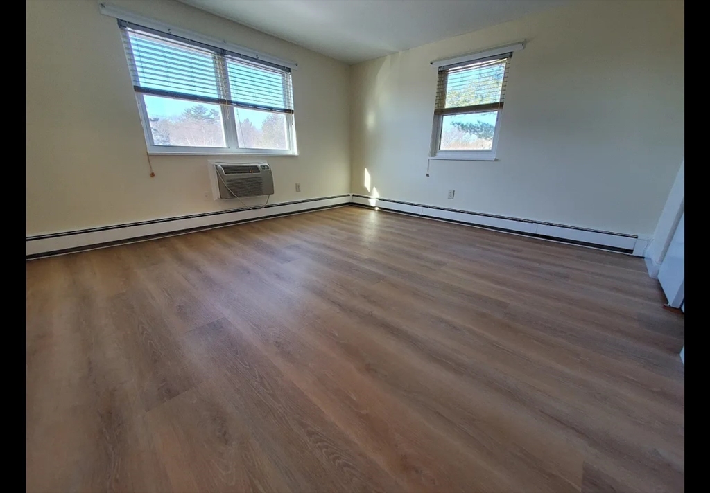 A2 Colonial Drive, Unit 10 Andover, MA 01810 - Photo 7 of 20 an empty room with wooden floor and windows