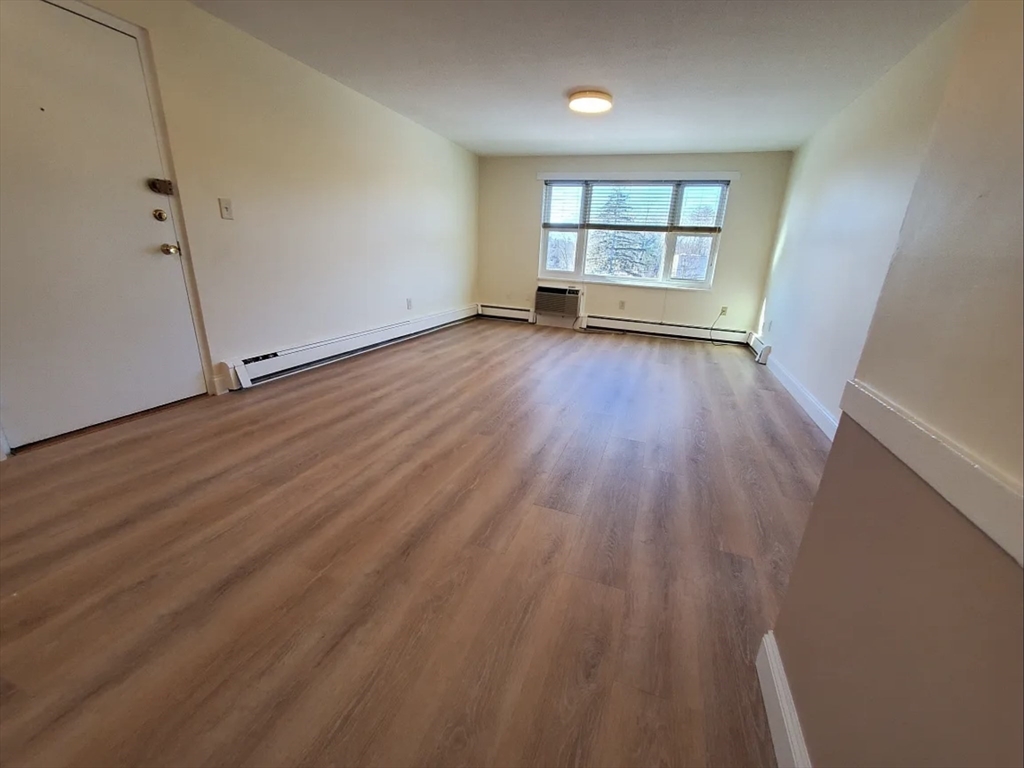 A2 Colonial Drive, Unit 10 Andover, MA 01810 - Photo 8 of 20 an empty room with wooden floor and windows