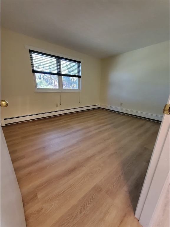 A2 Colonial Drive, Unit 10 Andover, MA 01810 - Photo 9 of 20 an empty room with wooden floor and windows