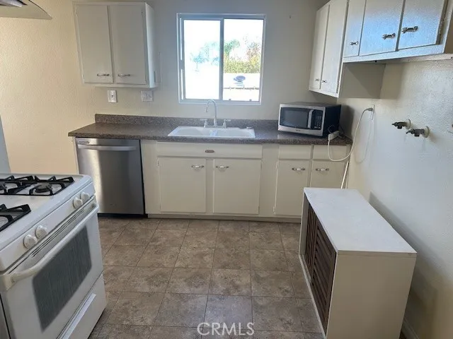 a kitchen with a sink stove and cabinets
