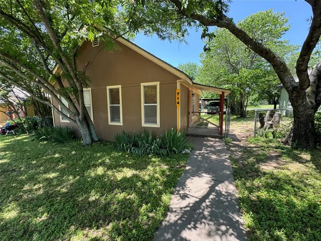 a view of backyard of house with green space