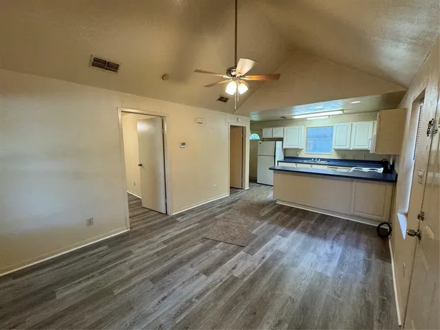 a view of kitchen with granite countertop cabinets and refrigerator
