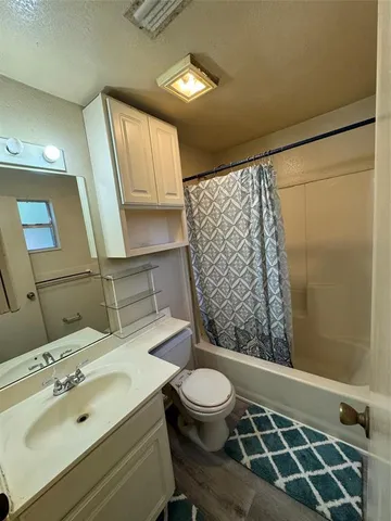 a bathroom with a sink mirror vanity and toilet