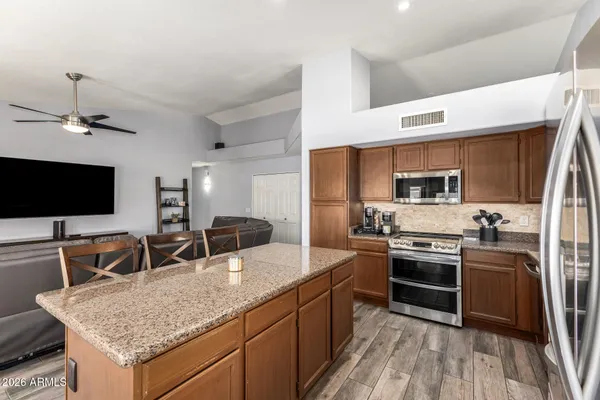 a kitchen with stainless steel appliances granite countertop a sink stove and refrigerator