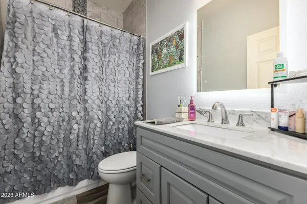 a bathroom with a granite countertop sink mirror vanity and toilet