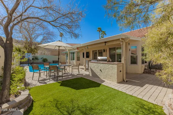 a view of a house with a backyard patio and sitting area