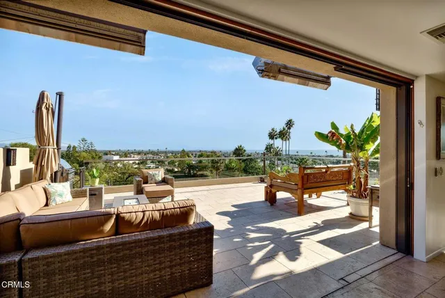 a kitchen with a sink a counter top space and living room view