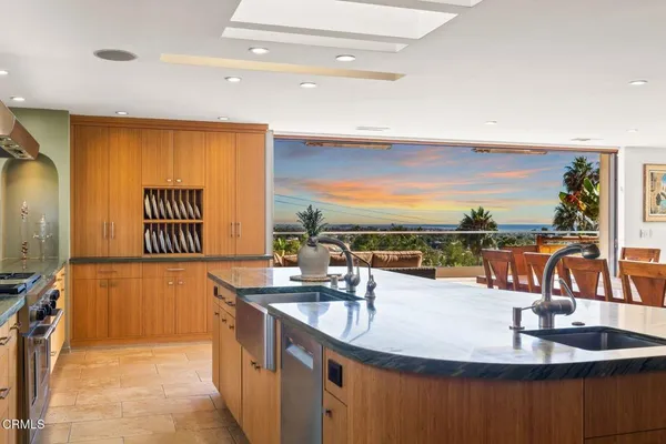 a kitchen with a sink dining table and chairs