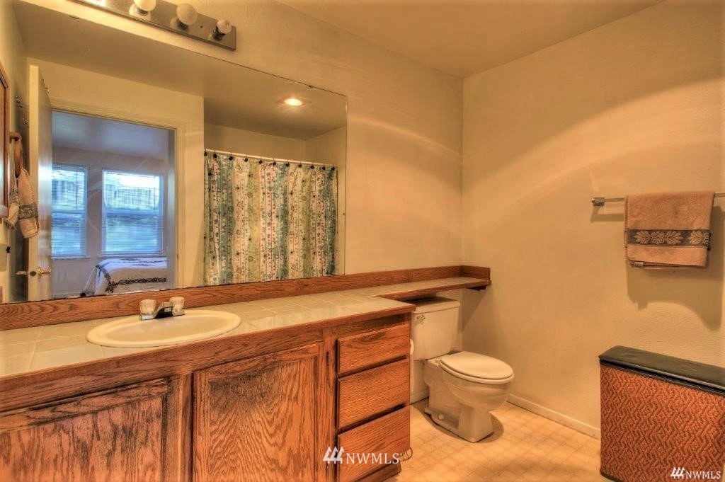 833 Southwest Sunset Boulevard, Unit E22 Renton, WA 98057 - Photo 4 of 18 a kitchen with stainless steel appliances granite countertop a stove a sink and a microwave