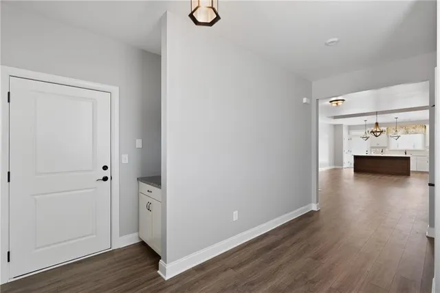 a view of a livingroom with a fireplace a chandelier and wooden floor
