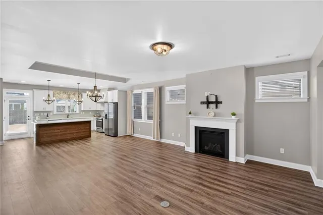 a bedroom with a large bed chandelier and a window