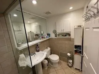 a bathroom with a sink a toilet a mirror and shower