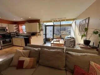 a living room with furniture a flat screen tv and a large window