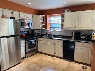 a kitchen with stainless steel appliances granite countertop a refrigerator sink and stove