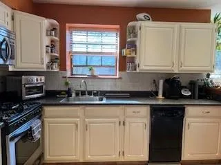 a kitchen with white cabinets and appliances