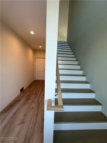 a kitchen with stainless steel appliances wooden floors and view living room