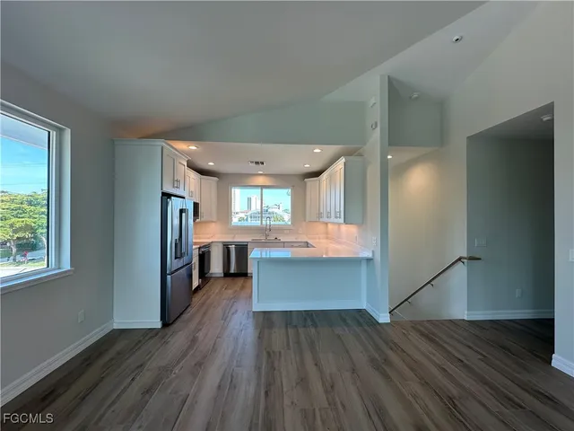 a large kitchen with cabinets stainless steel appliances and a counter top