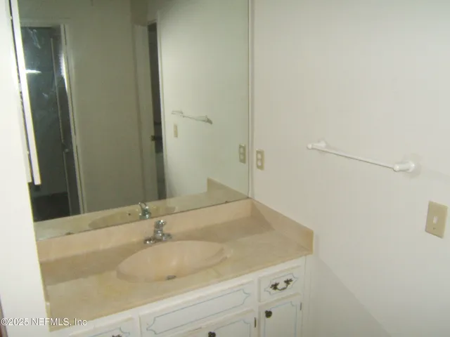 a bathroom with a granite countertop sink and mirror