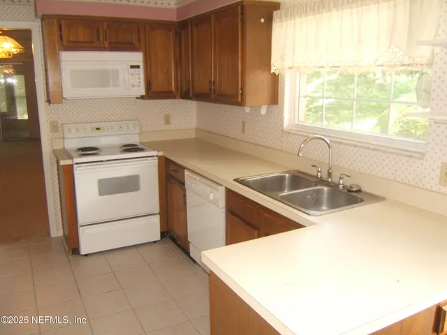 a kitchen with a sink a stove and a refrigerator