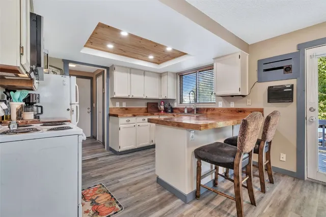 a kitchen with stainless steel appliances granite countertop a table chairs sink refrigerator and cabinets