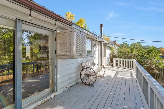 a view of a balcony with chairs and wooden floor