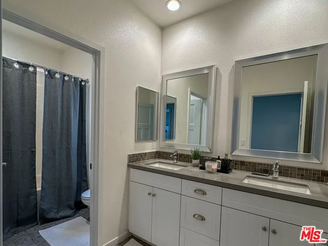 a bathroom with double vanity sinks and a mirror
