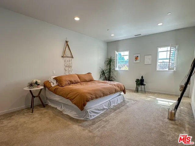 a spacious bedroom with a bed and a chair