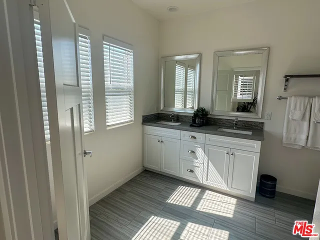 a spacious bathroom with a granite countertop sink a mirror and a shower