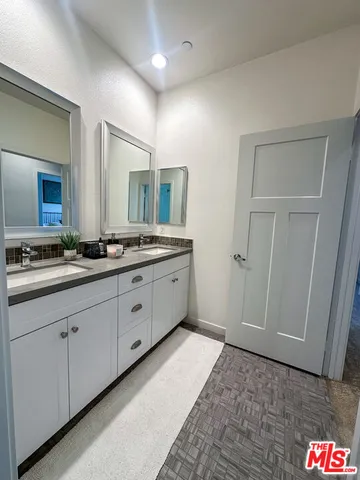 a spacious bathroom with a double vanity sink and a mirror