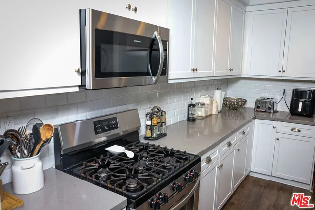 a kitchen with a stove and white cabinets