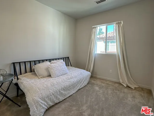 a large bed sitting in a bedroom next to a window