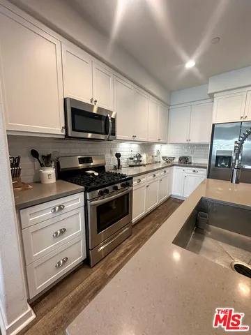 a kitchen with granite countertop a sink and steel appliances