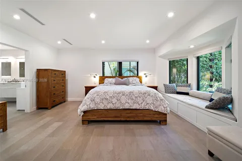 a spacious bedroom with a large bed and windows