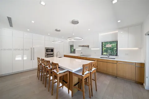 a kitchen with kitchen island a dining table and chairs