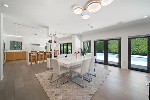 a dining room with furniture a chandelier and wooden floor