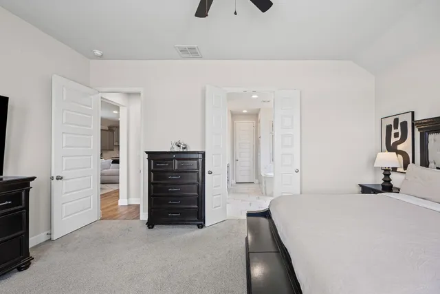 a bedroom with a bed and a flat tv screen on dresser