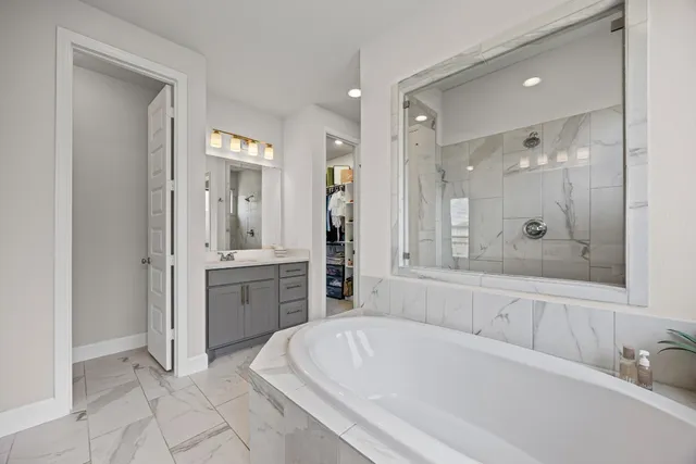 a bathroom with a tub sink and mirror