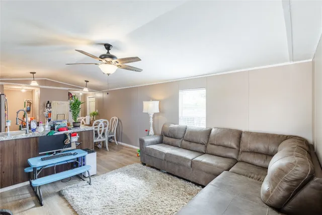 a living room with furniture a ceiling fan and a rug