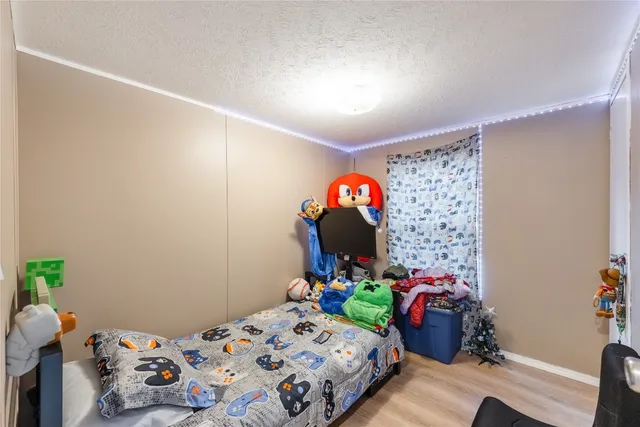 a bedroom with a bed and a wooden floor