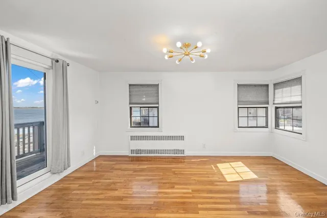 a view of a bedroom with wooden floor and windows