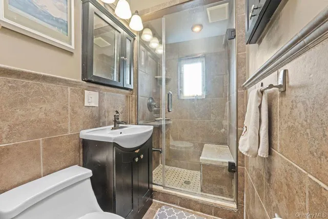 a bathroom with a sink a toilet and shower