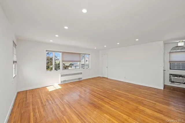 a view of kitchen with kitchen island wooden floor center island and stainless steel appliances