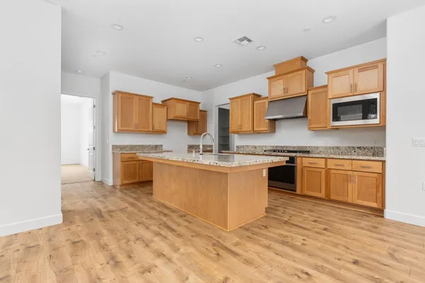 a kitchen with stainless steel appliances granite countertop a sink and stove top oven