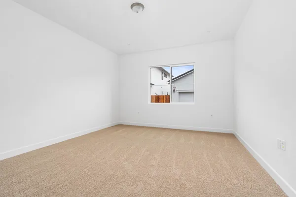 an empty room with a windows and a ceiling fan