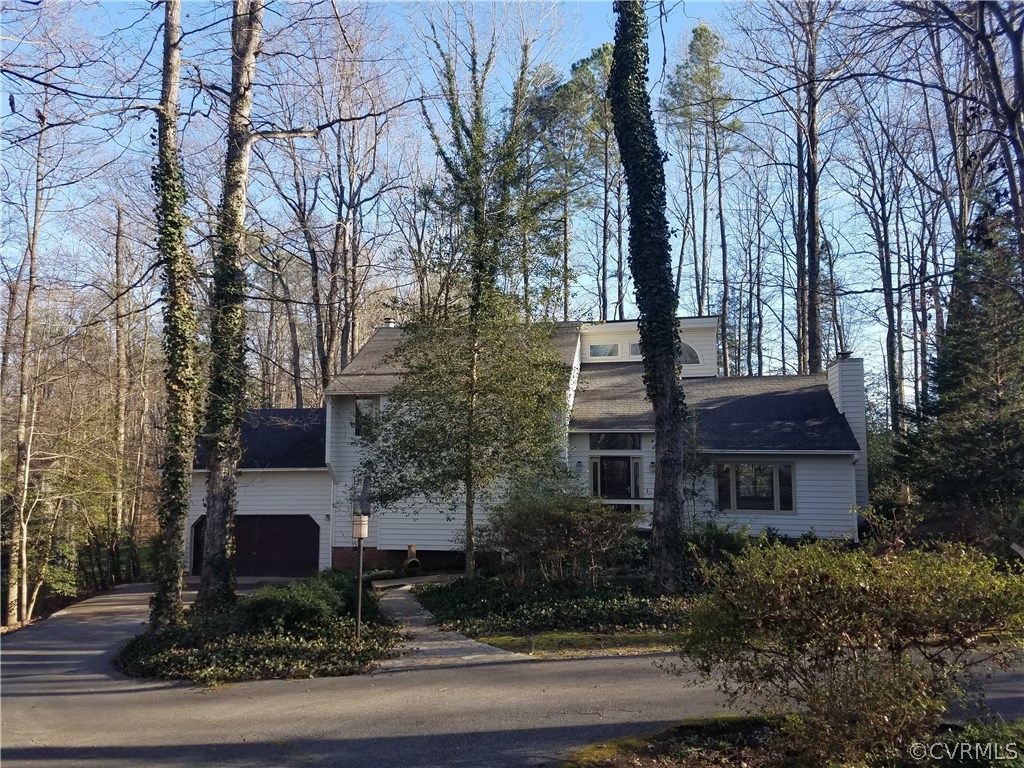 a front view of a house with trees and plants